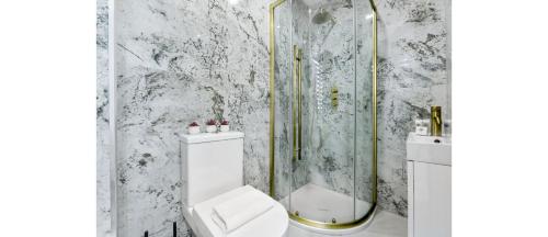 a white bathroom with a shower and a toilet at Sleek Modern 3BR Flat in Nunhead in London