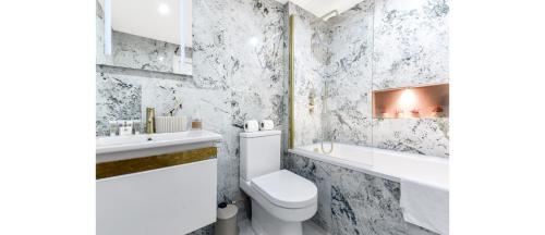 a white bathroom with a toilet and a sink at Sleek Modern 3BR Flat in Nunhead in London