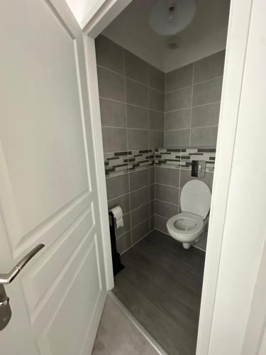 - une petite salle de bains avec des toilettes et une porte dans l'établissement La Victoria - Charmante maison en centre ville - Gare - Jardin, au Mans