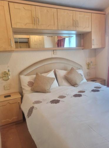 a bedroom with a white bed with brown spots on it at Sunrise Holidays Skegness - Emerald in Skegness