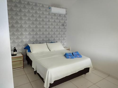 1 dormitorio con 2 camas con sábanas blancas y almohadas azules en Pousada Talismã, en Florianópolis
