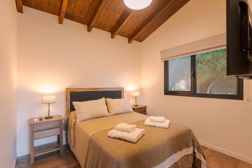 a bedroom with a bed with two towels on it at Los Maitenes in San Martín de los Andes