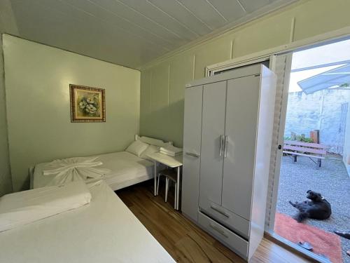 una habitación con 2 camas y un perro tirado en el suelo en Pousada Familiar, en São Gabriel