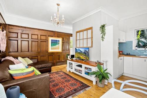 ein Wohnzimmer mit Sofa und Tisch in der Unterkunft Seabreeze Cottage Bundeena in Bundeena