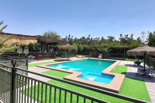 una piscina en un patio con una valla en Cabaña en Pirque