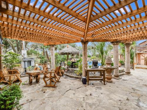 a wooden pergola with chairs and tables on a patio at Cozy Oasis in SE Austin in Buda