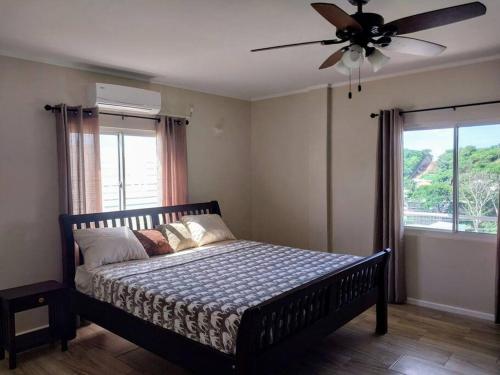 a bedroom with a bed with a ceiling fan at 2BR apt near restaurant, beach, nightlife & convenience store in Lance aux Épines