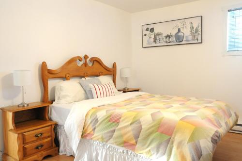 um quarto com uma cama com um edredão colorido em Logis des prodiges em Rouyn