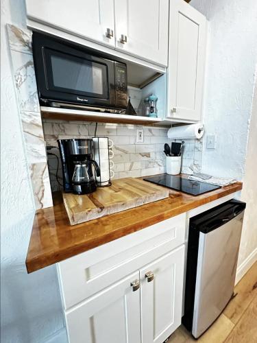 a kitchen with white cabinets and a microwave at OCEAN FRONT Condo Daytona Beach! in Daytona Beach