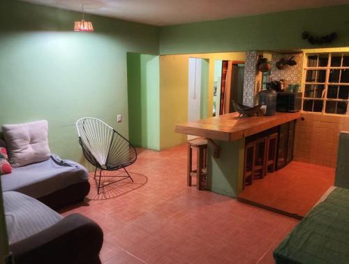 een woonkamer met een bank, een tafel en een stoel bij Sueño de bugambilia in Oaxaca City