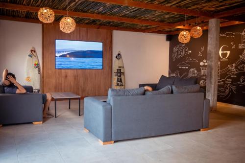 a person sitting on two couches in a living room at Las Golondrinas Mar del Plata in Mar del Plata