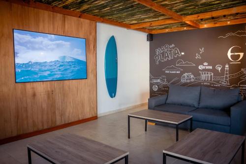 a living room with a couch and a surfboard on a wall at Las Golondrinas Mar del Plata in Mar del Plata