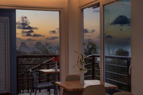a balcony with a table and a view of the mountains at Pousada Mar em Mim in Fernando de Noronha