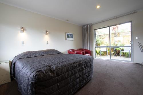 a bedroom with a bed and a large window at Annabelle Motel in Hokitika