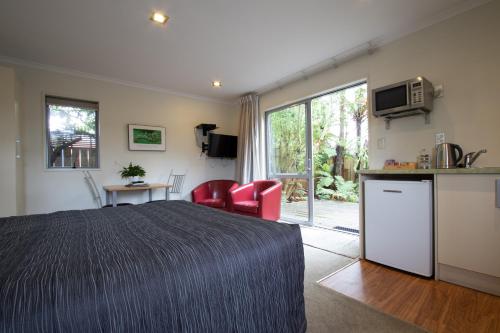 a hotel room with a bed and a kitchen and a kitchen at Annabelle Motel in Hokitika