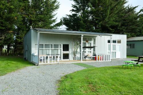 a large white shed with a patio and a table at Miranda Farm close to airport！ in Kaiapoi