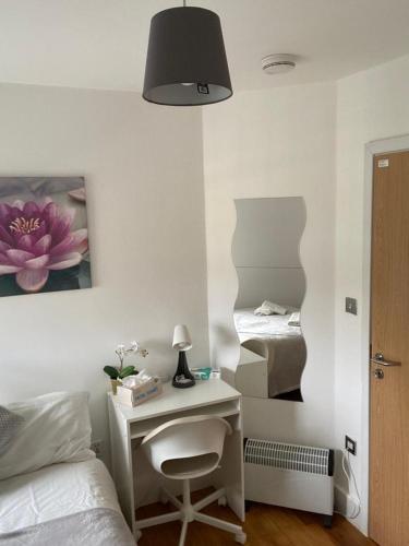 a bedroom with a desk and a bed with a lamp at Lovely Private Rooms in Euston, Central London in London