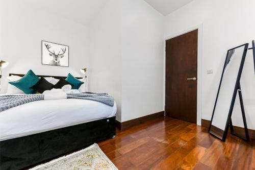 - une chambre avec un grand lit et du parquet dans l'établissement Vibrant 1 BD Retreat - Perfect for Couples, à Hanwell