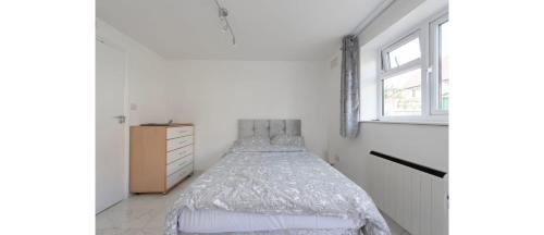 a white bedroom with a bed and a window at Newly Renovated Cozy Studio in North London in London