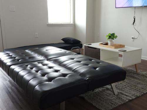 un divano in pelle nera in soggiorno con scrivania di Beale Streeters Delight a Memphis