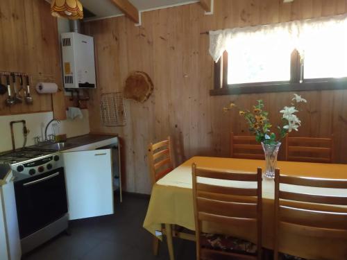 a kitchen with a table with a yellow table cloth at Cabañas Vista al Lago in Ensenada