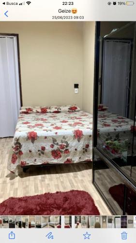 1 dormitorio con cama con colcha de flores y espejo en Apartamento caminho de Moisés, en Maragogi