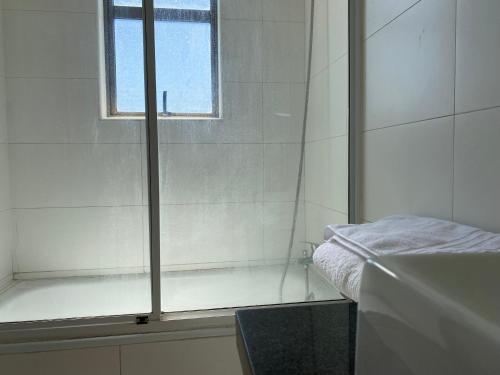 a bathroom with a shower and a sink and a window at BUIN CENTRO Departamento in Maipo