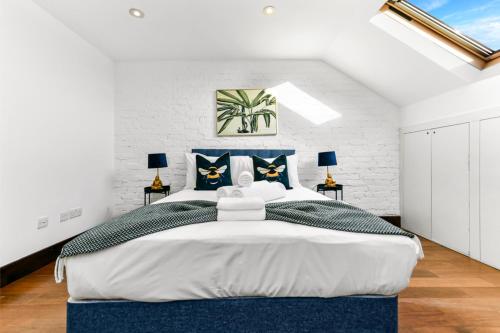 a bedroom with a large bed with blue accents at Fresh and Cosy Two Bedroom Flat in Hanwell