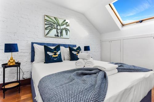 una camera da letto con un grande letto con cuscini blu di Fresh and Cosy Two Bedroom Flat a Hanwell