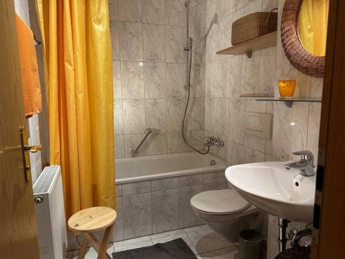 e bagno con lavandino, servizi igienici e vasca. di Sachrang: Ferien-Wohnung am See mit Bergblick a Sachrang