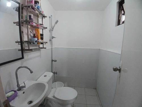 a bathroom with a white toilet and a sink at Transient Home Abucay Bataan - 2 BR in Abucay Hacienda