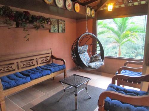 a living room with a blue couch and a swing at Sítio Cachoeirinha in Marechal Floriano