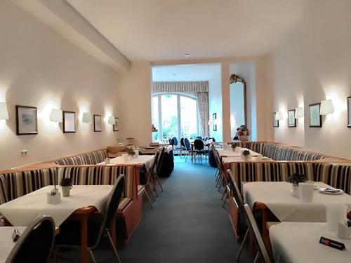 ein Esszimmer mit Tischen und Stühlen in einem Restaurant in der Unterkunft Hotel Mozart Bonn in Bonn