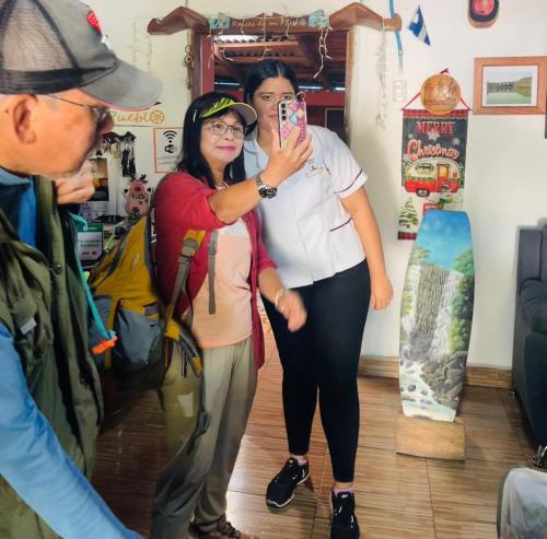 two women are taking a picture with a snowboard at Hostal Raíces de mi Pueblo in Suchitoto