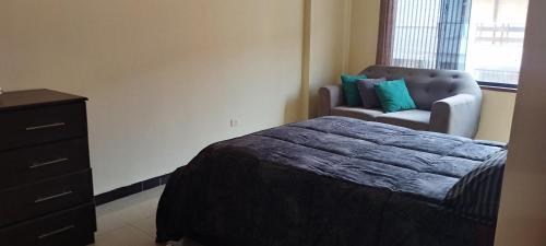 1 dormitorio con 1 cama, vestidor y silla en Departamento Huanchaco, en Huanchaco