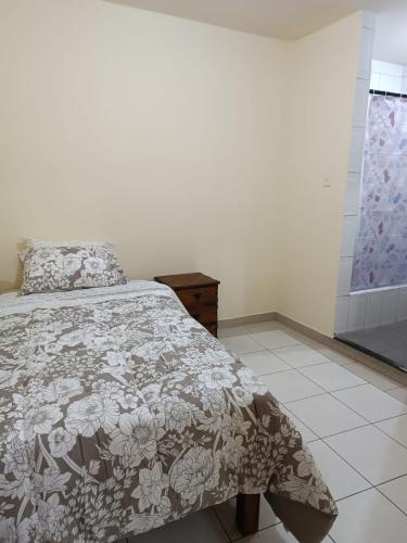 a bedroom with a bed with a floral bedspread at Departamento Huanchaco in Huanchaco
