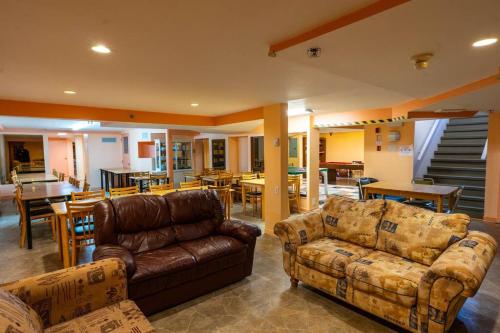 uma sala de estar com sofás de couro e uma sala de jantar em 235 Véranda sous tout son charme em Trois-Rivières