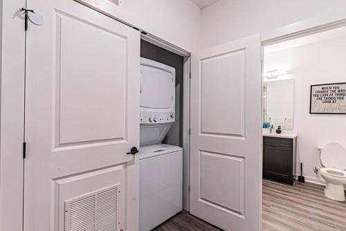 a bathroom with a toilet and a white door at Posh Living Condo 