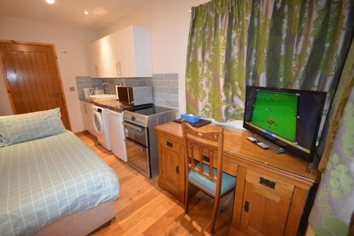 a small kitchen with a bed and a television on a desk at 160 Westminster Way,Fab studio room in Oxford