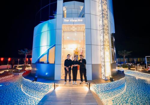 a group of three men standing in front of a building at Pentacity Hotel Balikpapan in Balikpapan