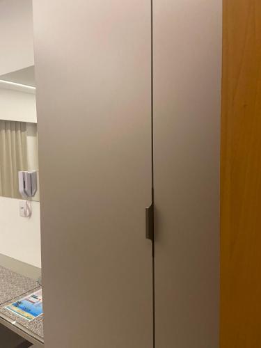 a white cabinet with a door in a room at Makia114experience in Porto De Galinhas