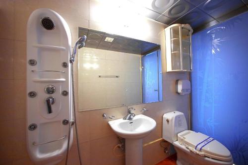 a bathroom with a sink and a toilet and a mirror at New World Hotel Yongsan in Seoul