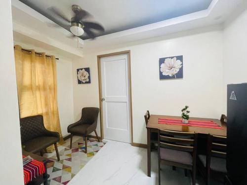 a dining room with a table and chairs and a ceiling fan at A relaxing and accessible condominium unit. in Manila