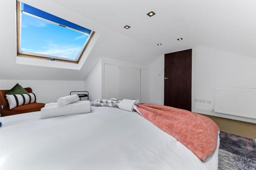 Schlafzimmer mit einem großen Bett und einem Fenster in der Unterkunft Tranquil Terra - Cozy and Soothing Vibe in Hanwell