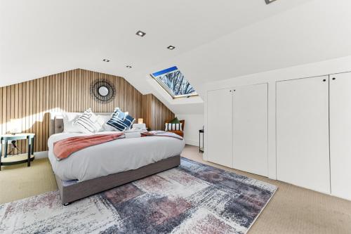 a bedroom with a large bed and a skylight at Tranquil Terra - Cozy and Soothing Vibe in Hanwell