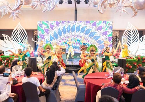 a group of people watching a performance in front of a stage at Pentacity Hotel Balikpapan in Balikpapan