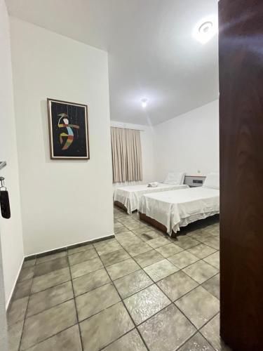 Pokój z dwoma łóżkami i obrazem na ścianie w obiekcie Malakoff Residence w mieście Recife