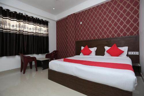 a bedroom with a large bed with red pillows at OYO Hotel Vandana in Alwar