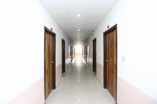 an empty corridor of a hospital with wooden doors at OYO Hotel Vandana in Alwar