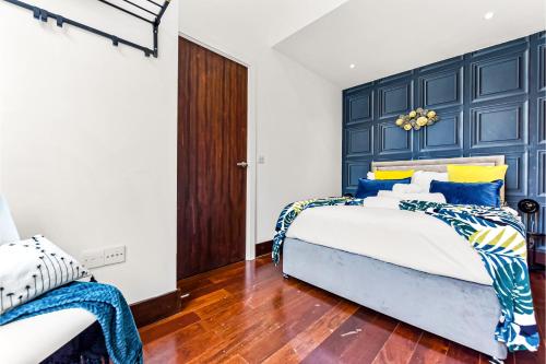 Comfortable 3 Bedroom Apartment in Greater London في Hanwell: غرفة نوم مع سرير كبير مع اللوح الأمامي الأزرق